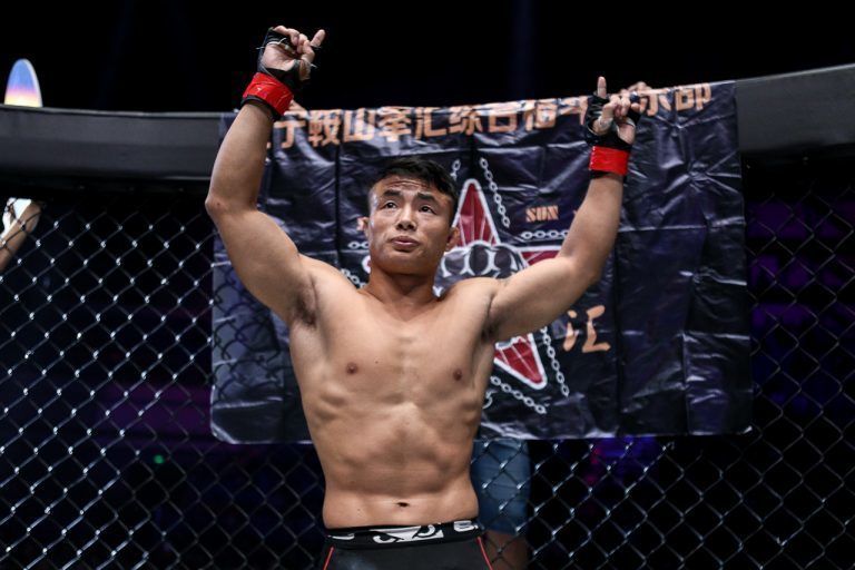 Chinese flyweight Bu Huo You Ga raises his arms in victory