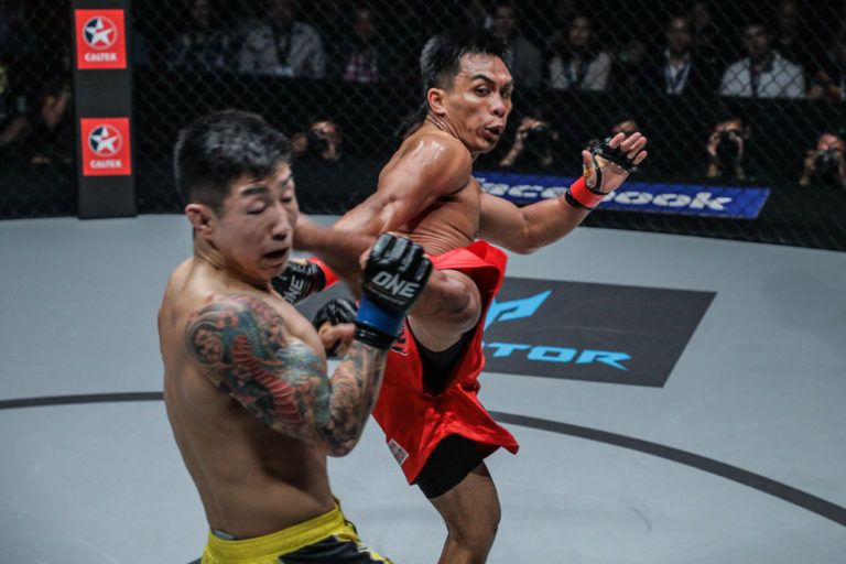 Team Lakay's Kevin Belingon hits a head kick on Kevin Chung