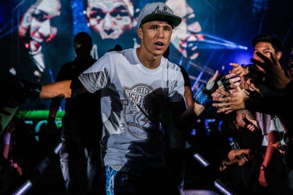 Flyweight MMA star Reece McLaren high fives fans on the way to the cage