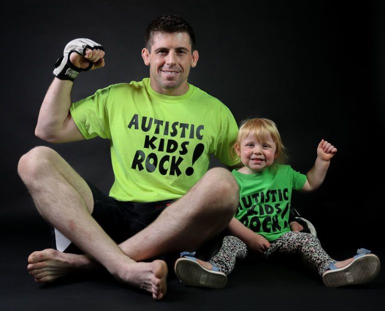 American MMA fighter Tyler McGuire poses with his daughter in their Autism Rocks shirts
