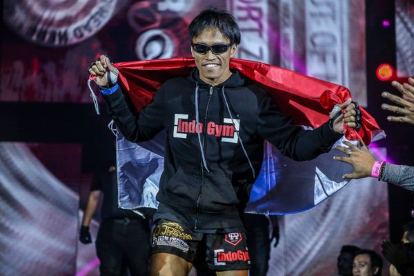 Indonesian MMA fighter Sunoto carries the Indonesian flag to the cage