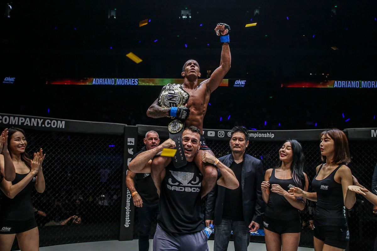 ONE Flyweight World Champion Adriano Moraes is raised upon his cornerman's shoulders