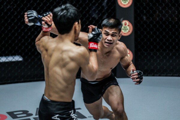 Indonesian wrestling star Eko Roni Saputra lunges forward with a cross on Niko Soe.