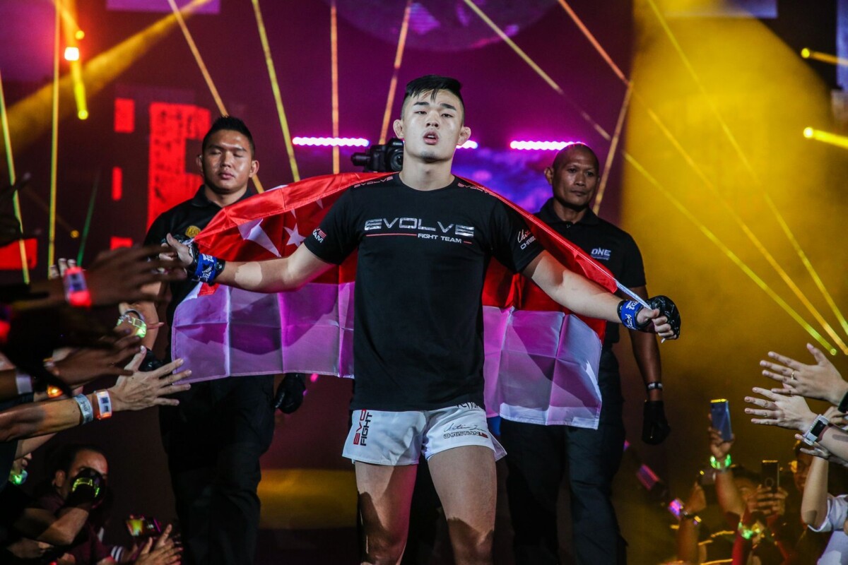 ONE Lightweight World Champion Christian Lee enters the arena with the Singapore flag