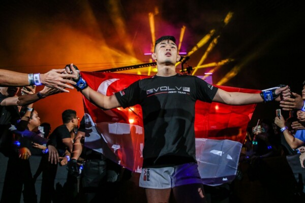 Christian Lee enters the arena with the Singapore flag