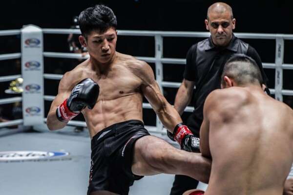 Japanese Muay Thai fighter Hiroki Akimoto throws a kick to Kenny Tse's gut