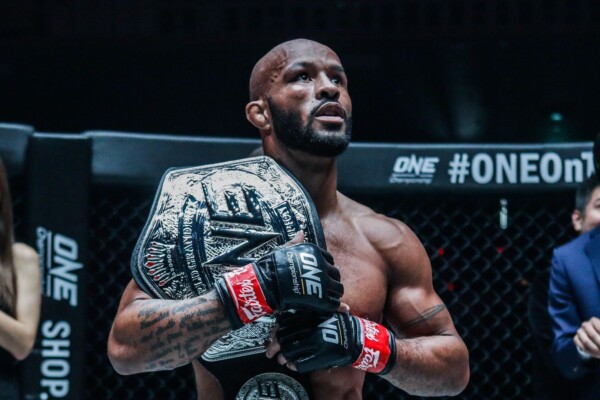 Following a tough battle, American star Demetrious Johnson poses with the ONE Flyweight World Grand Prix Championship belt