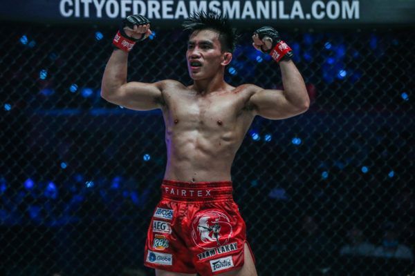 Joshua Pacio flexes after retaining his strawweight gold at ONE: FIRE & FURY.