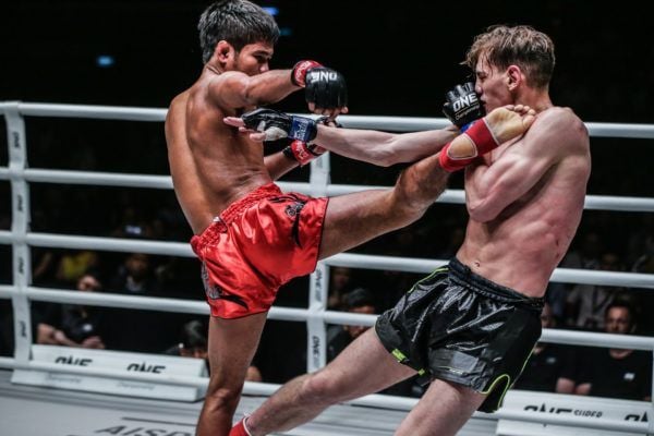 Thailand's Muangthai PK. Saenchaimuaythaigym connects with a head kick on the towering Brice Delval