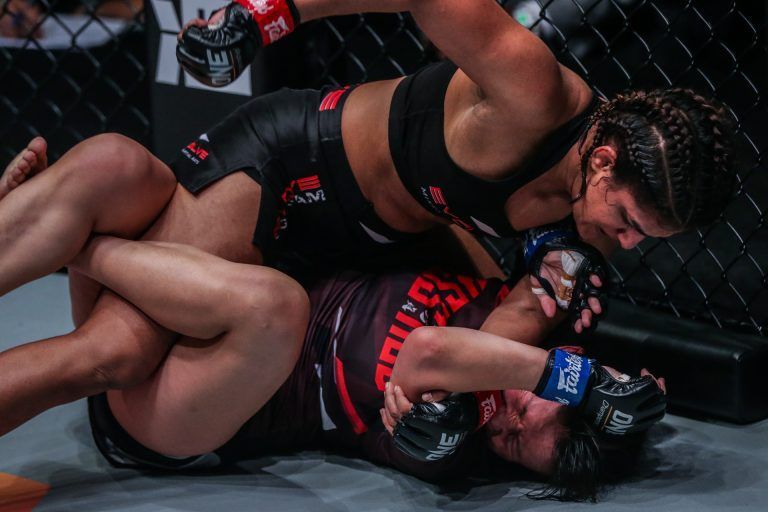 Indian wrestler Ritu Phogat punches Chinese athlete Wu Chiao Chen on the ground