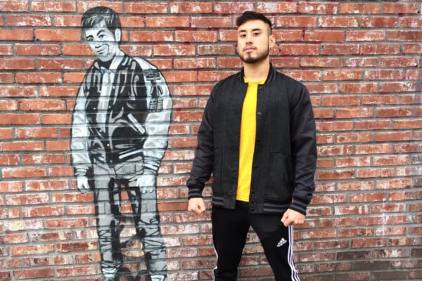 James Yang poses against a Bruce Lee mural