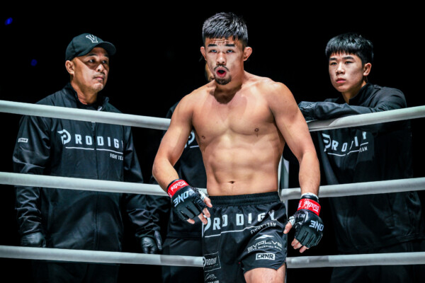 Christian Lee stands in the corner with father, Ken, and brother, Adrian, behind the ropes