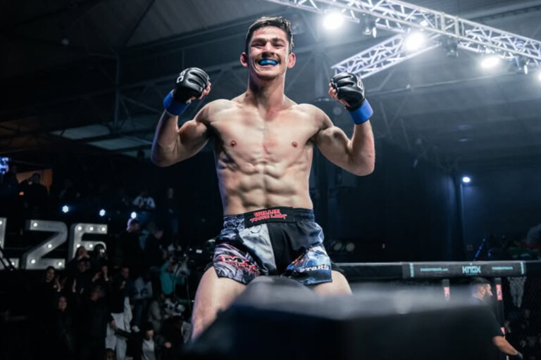 MMA fighter Willie van Rooyen sits on top of the cage