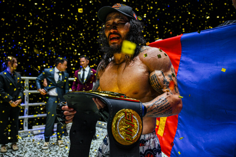 Enkh Orgil Baatarkhuu celebrates his World Title win with the Mongolian flag in the background