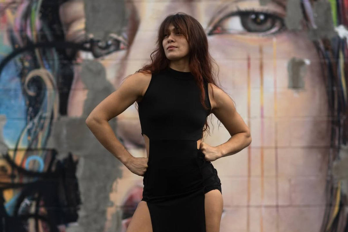 Teshya Noelani Alo poses against a wall full of graffiti