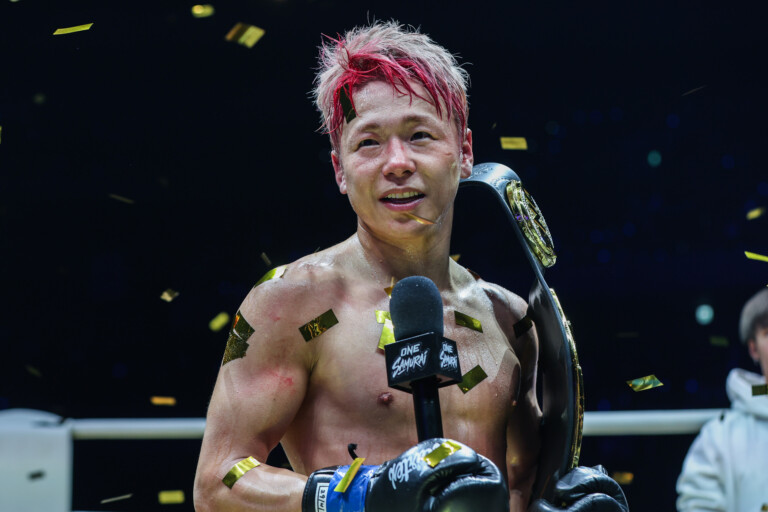 Takeru Segawa holds the microphone and his ONE Championship belt