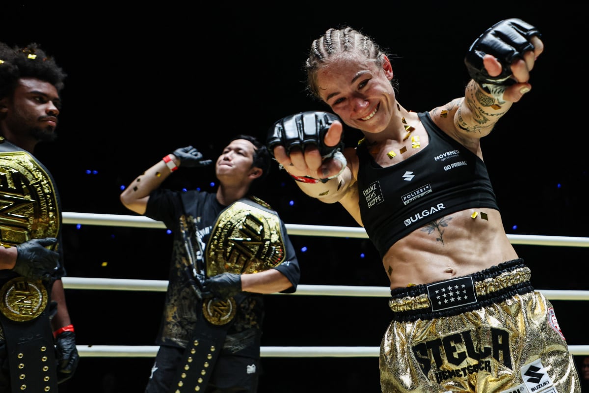 Stella Hemetsberger celebrates her World Title victory with her team and two ONE Championship belts
