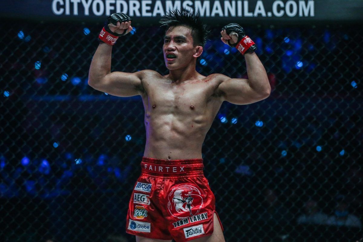 Joshua Pacio flexes after retaining his strawweight gold at ONE: FIRE & FURY.