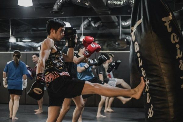 Students practice teeps on a heavy bag