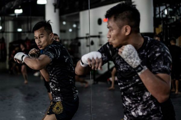 Sagetdao Petpayathai practices his hook while staring in the mirror