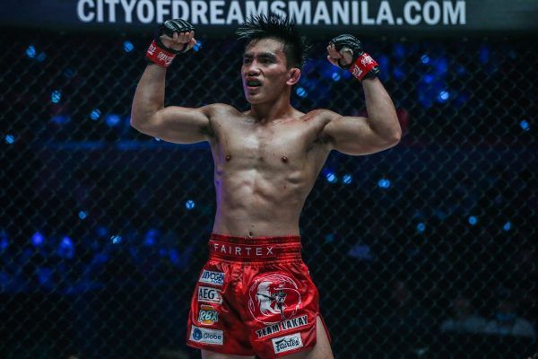 Joshua Pacio flexes after retaining his strawweight gold at ONE: FIRE & FURY.
