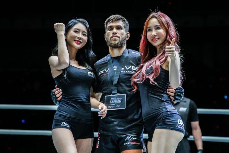 Finnish mixed martial arts star Aleksi Toivonen with the ring girls and his winner's medal in July 2019